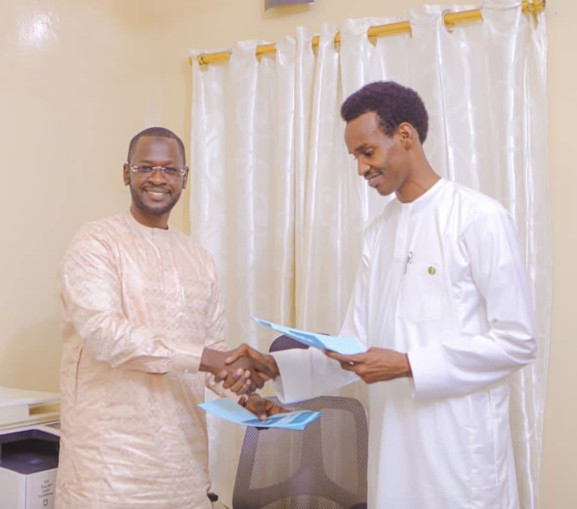 Two men stand and shake hands