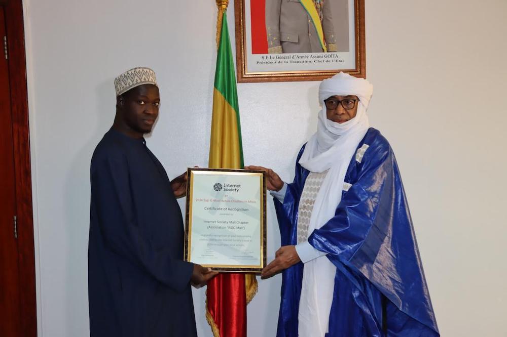 Two men hold an Internet Society certificate between them