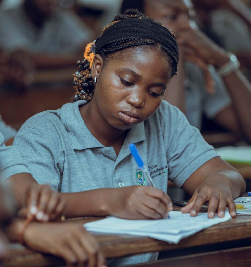 A young woman sits and writes on a piece of paper